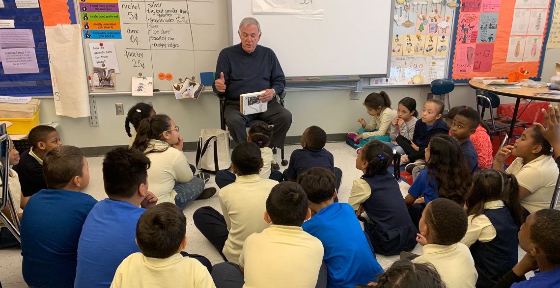 Roger Tilles reading with students in a classroom
